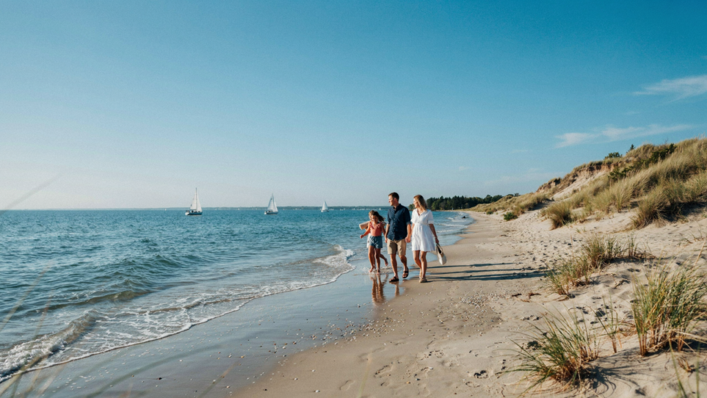 Family walking along a Lake Michigan beach near sand dunes in Michigan